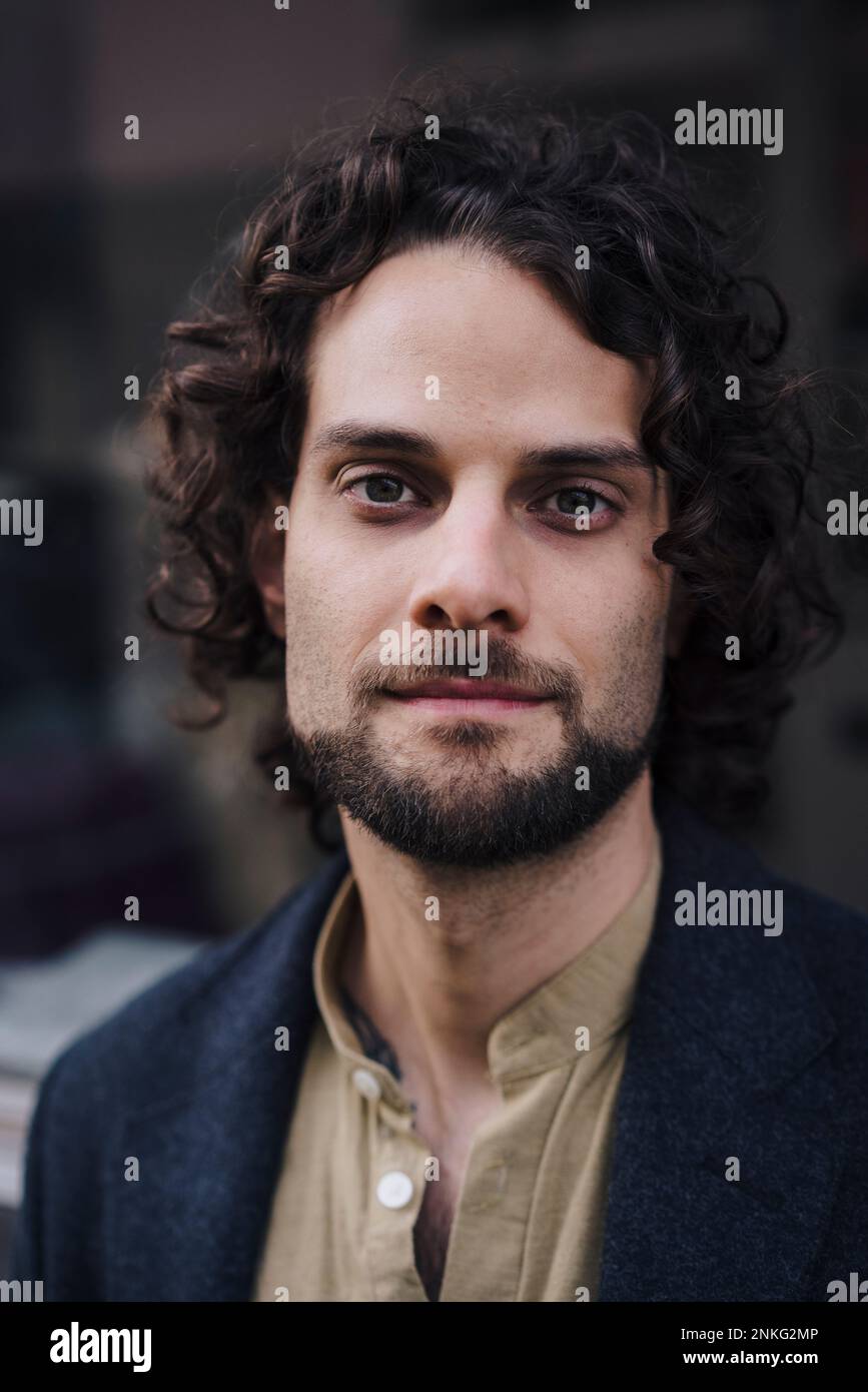 Confident young businessman with curly hair Stock Photo