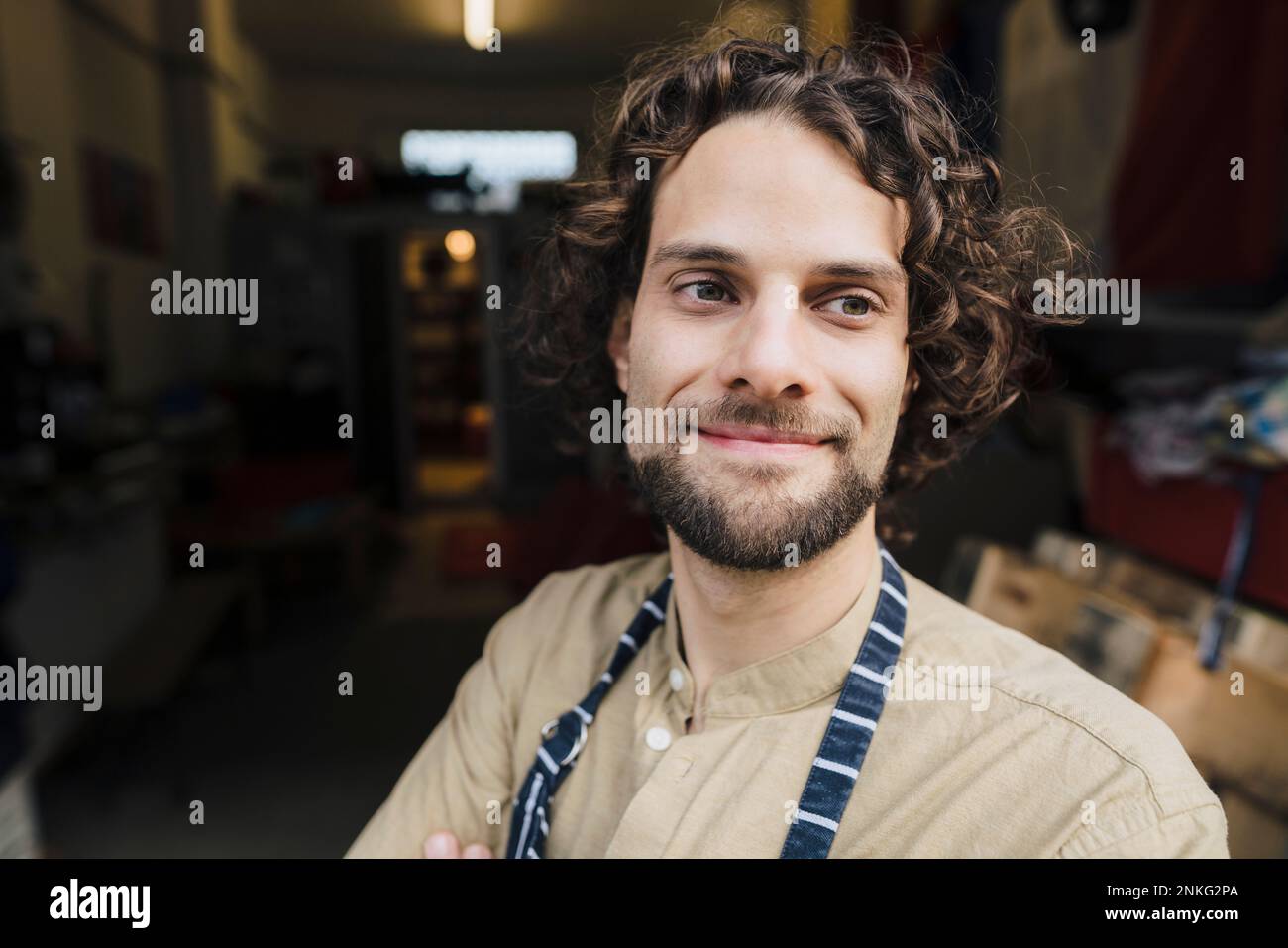 Thoughtful young businessman with curly hair in storage room Stock Photo