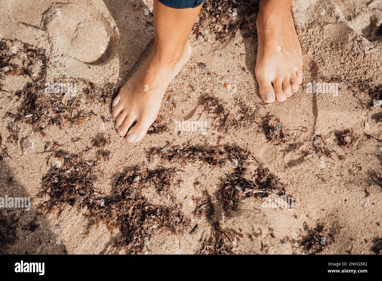 Woman standing barefoot on sand at beach Stock Photo - Alamy