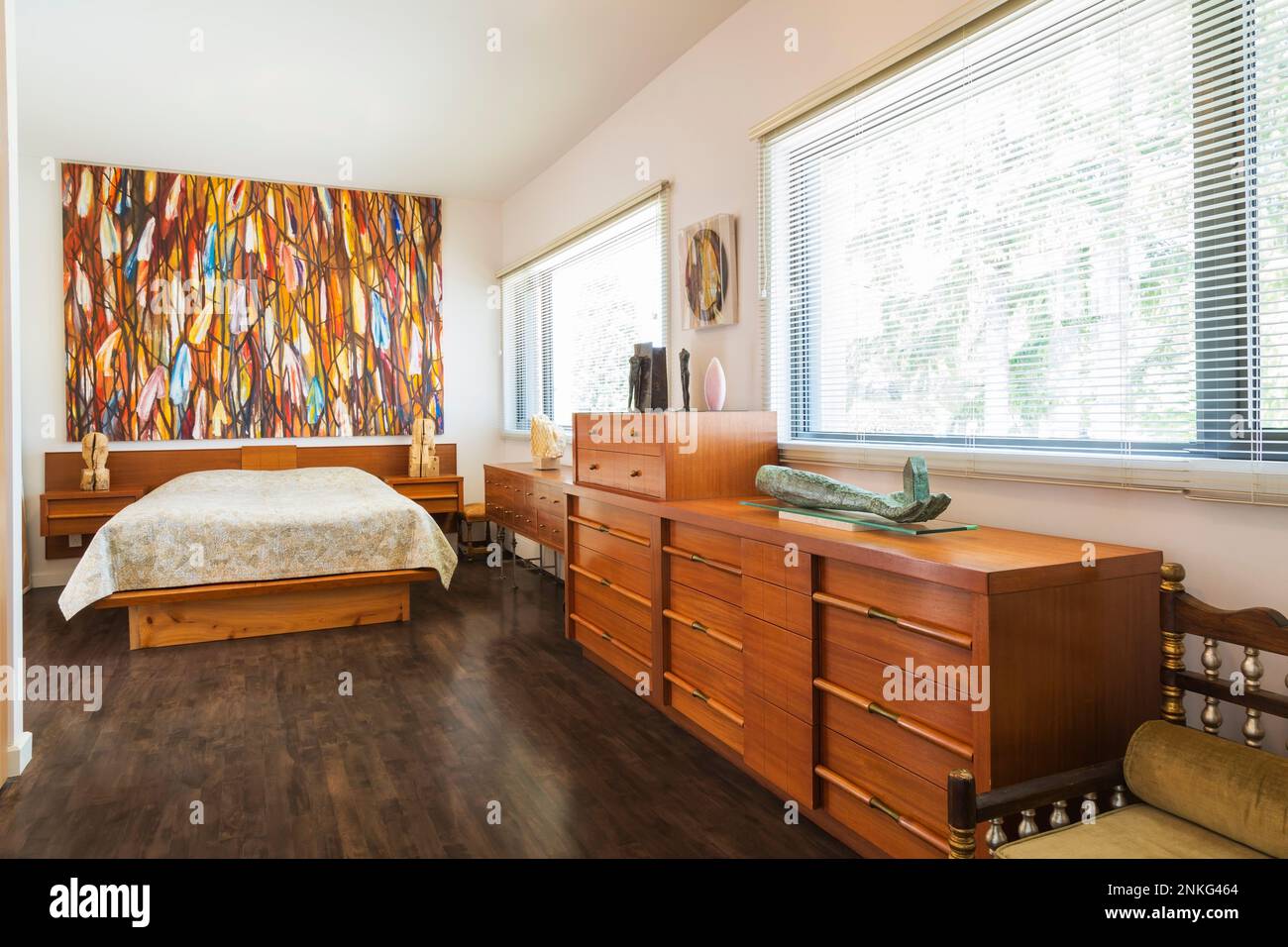 Wood frame queen size bed with wooden headboard and dresser in master