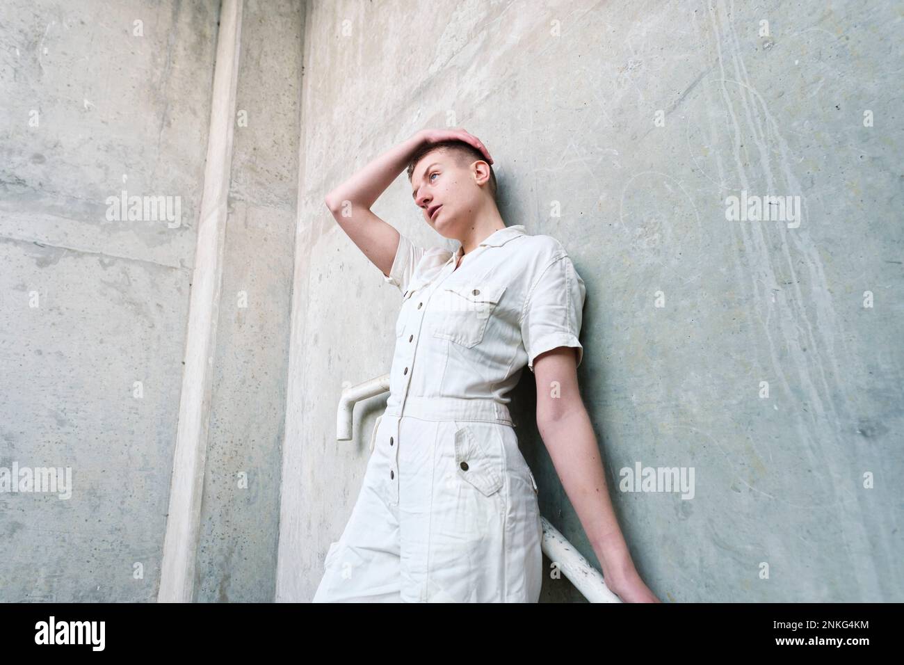 Thoughtful non-binary person leaning on wall Stock Photo