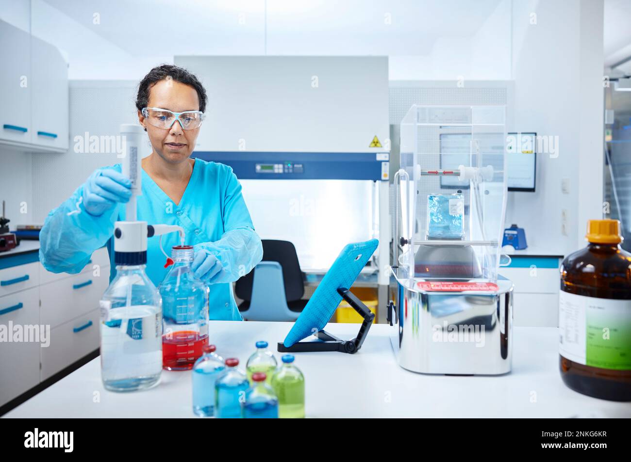 Female scientist mixing liquids in a microbiological lab Stock Photo