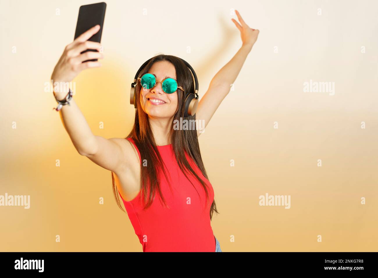 Smiling woman with steampunk glasses taking selfie on smart phone Stock Photo