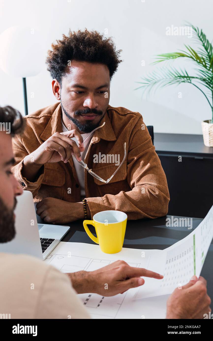Businessman and colleague discussing over documents Stock Photo