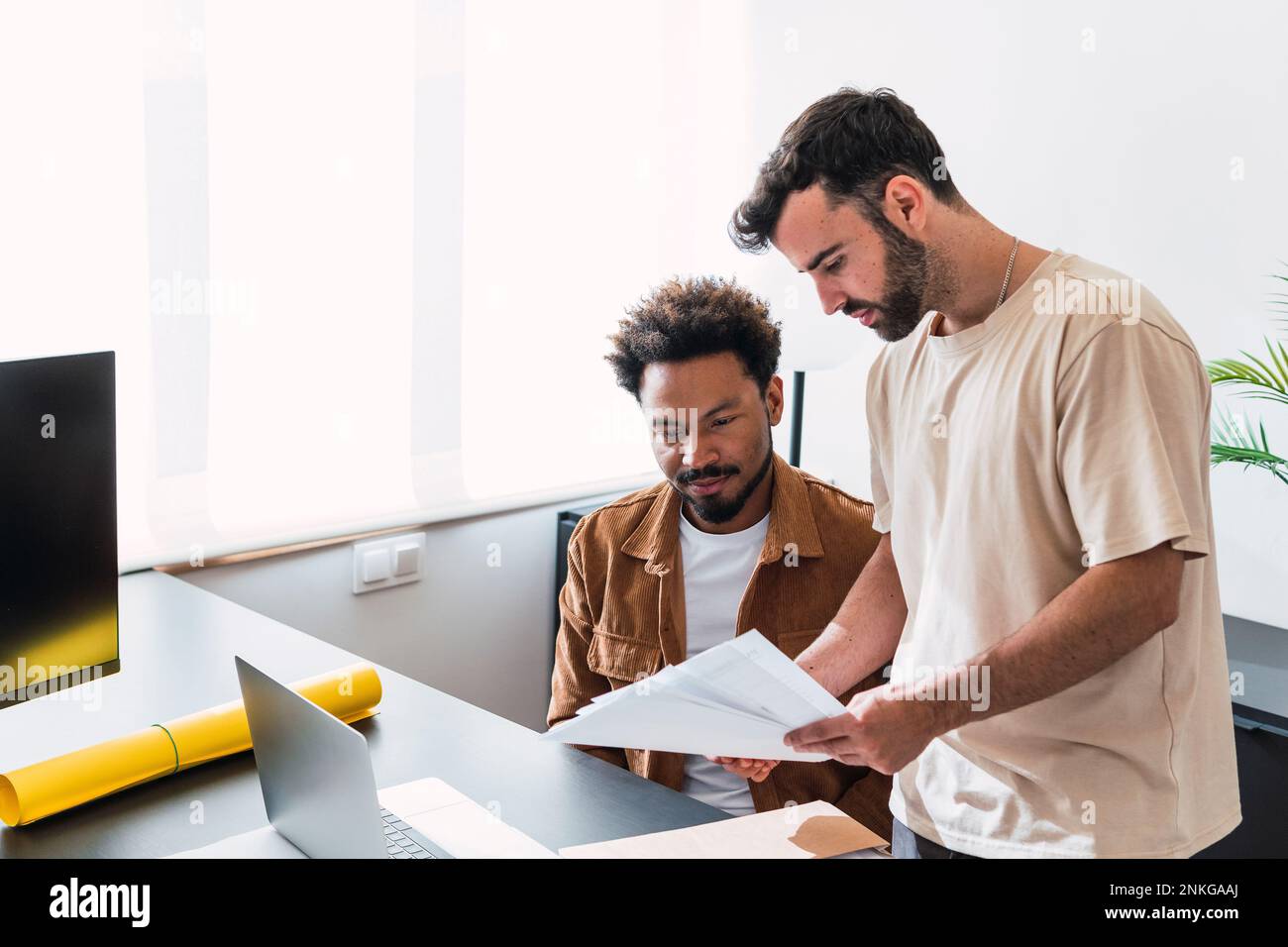 Businessman discussing over documents with colleague at office Stock Photo