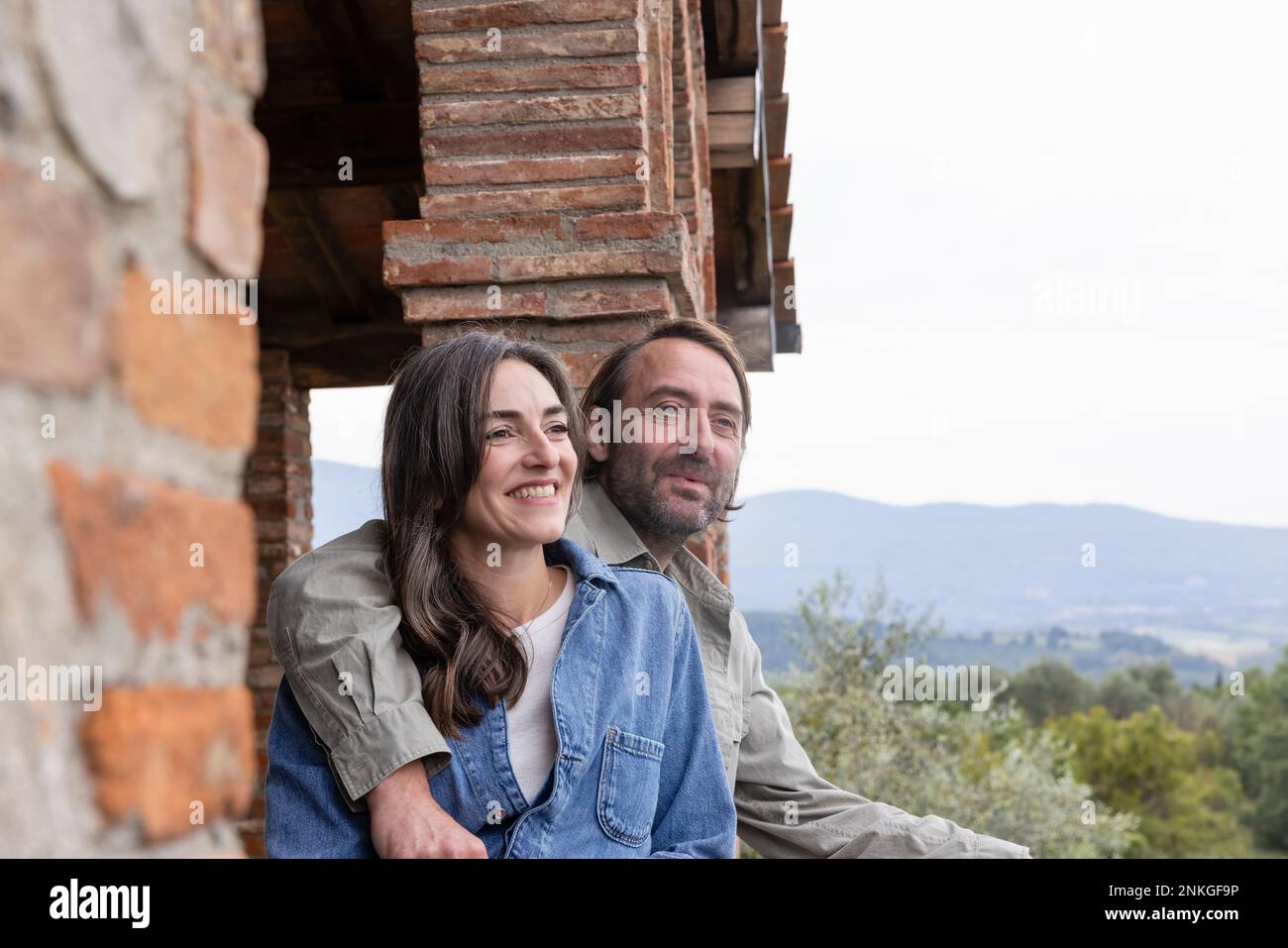 Happy woman with man sitting on rooftop Stock Photo - Alamy