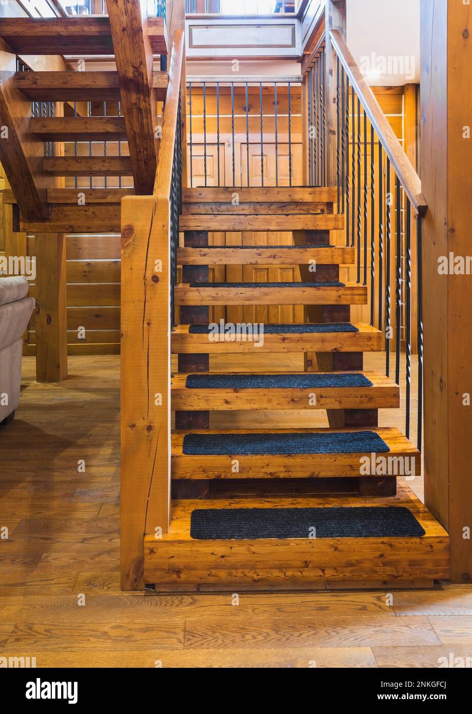 Wooden staircase and banister with black wrought iron spindles and