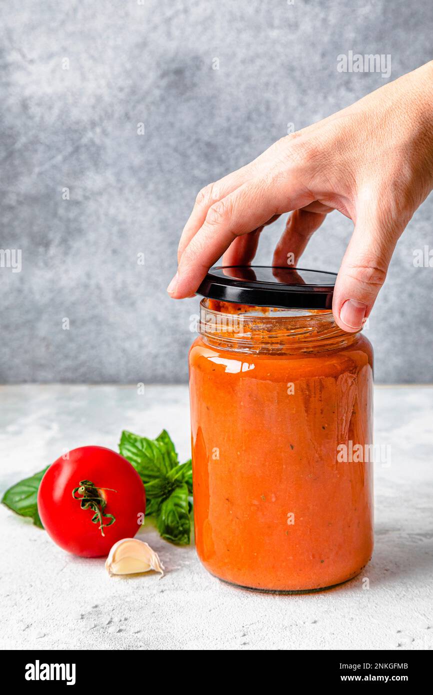 Hand of woman opening tomato sauce jar's lid Stock Photo Alamy