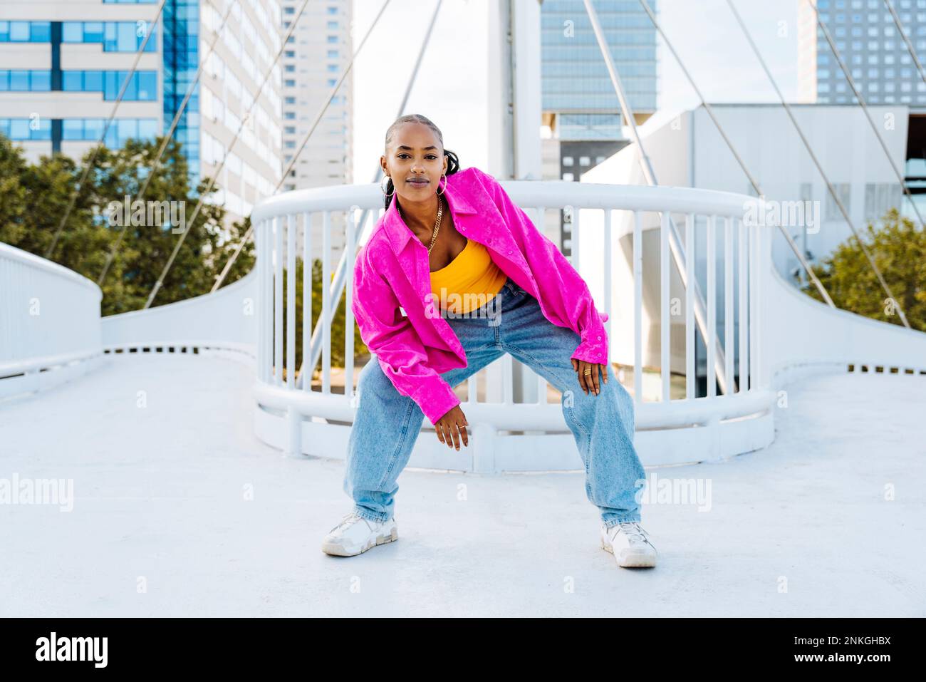Confident young dancer breakdancing on footbridge Stock Photo