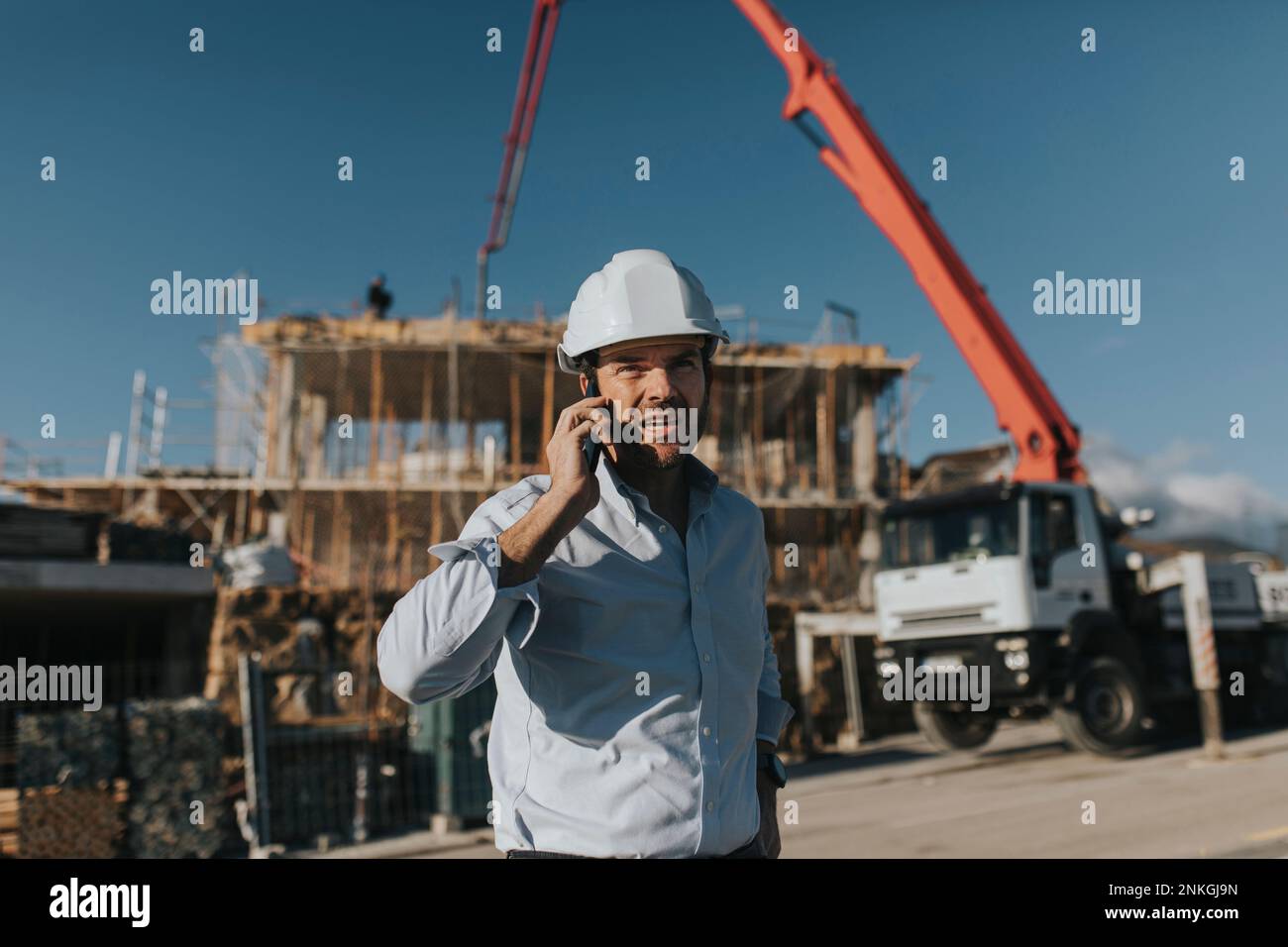 Architect talking on mobile phone at construction site Stock Photo