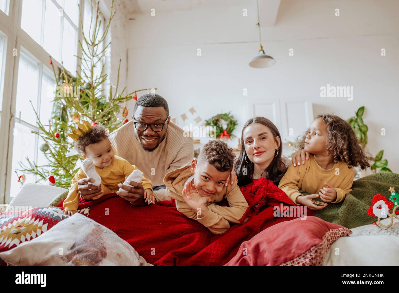 Happy parents with daughters and son enjoying in living room at Christmas Stock Photo