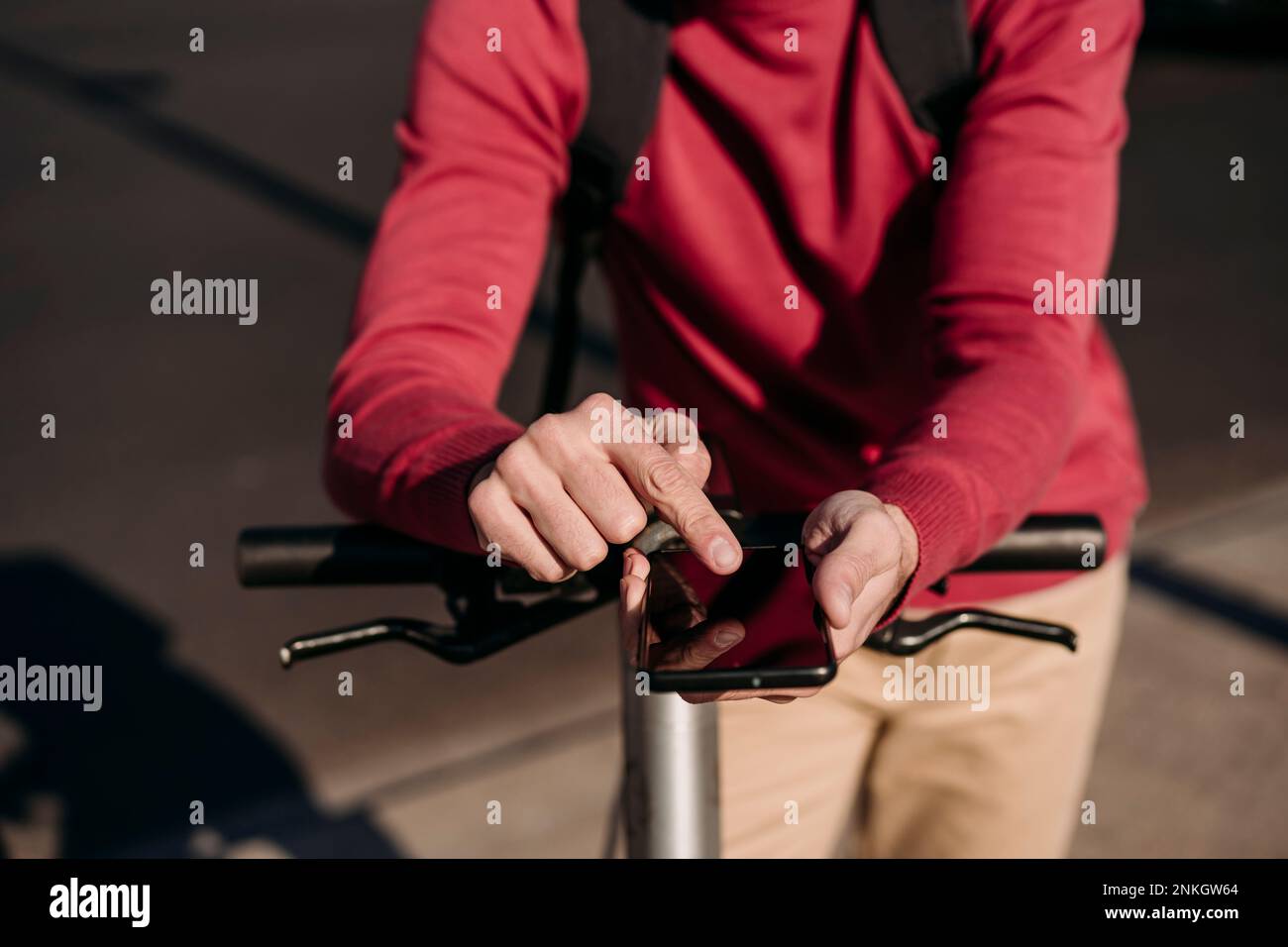 Young man with electric push scooter using smart phone Stock Photo