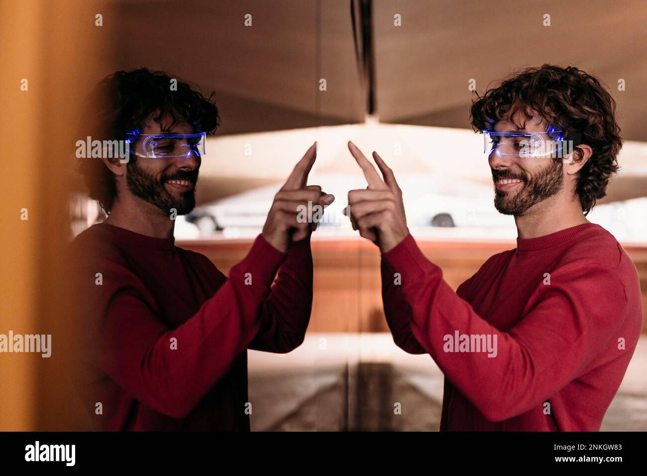 Smiling man wearing smart eyeglasses using touch screen in underground