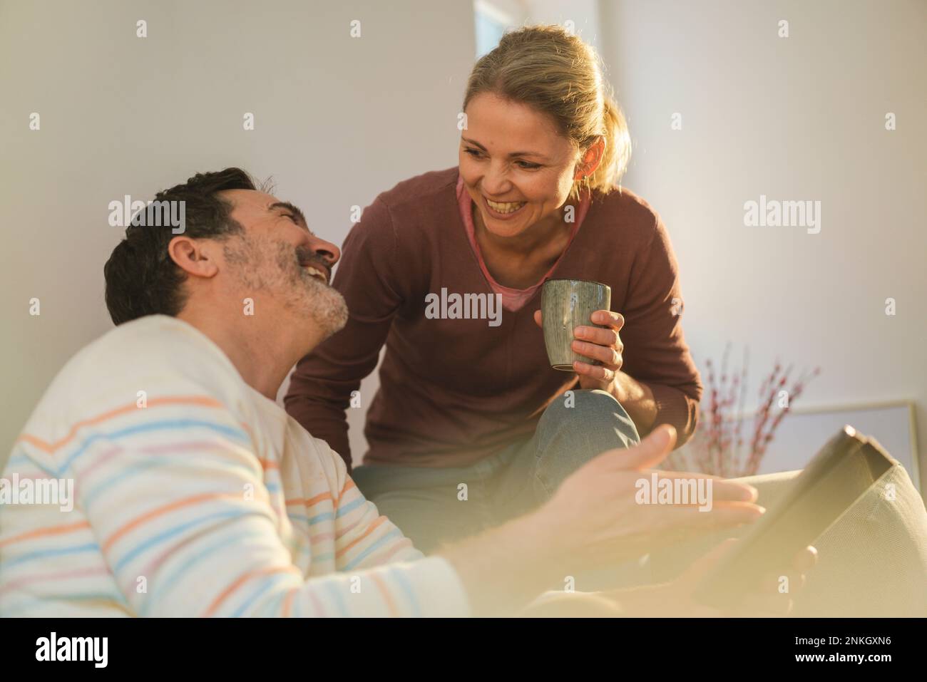 Happy woman talking to mature man gesturing at home Stock Photo