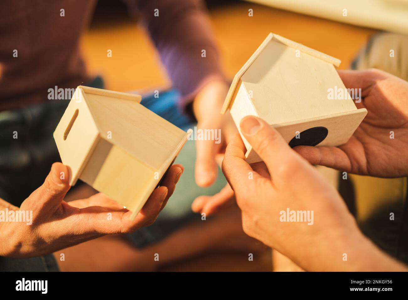 Hands of couple holding house models Stock Photo - Alamy