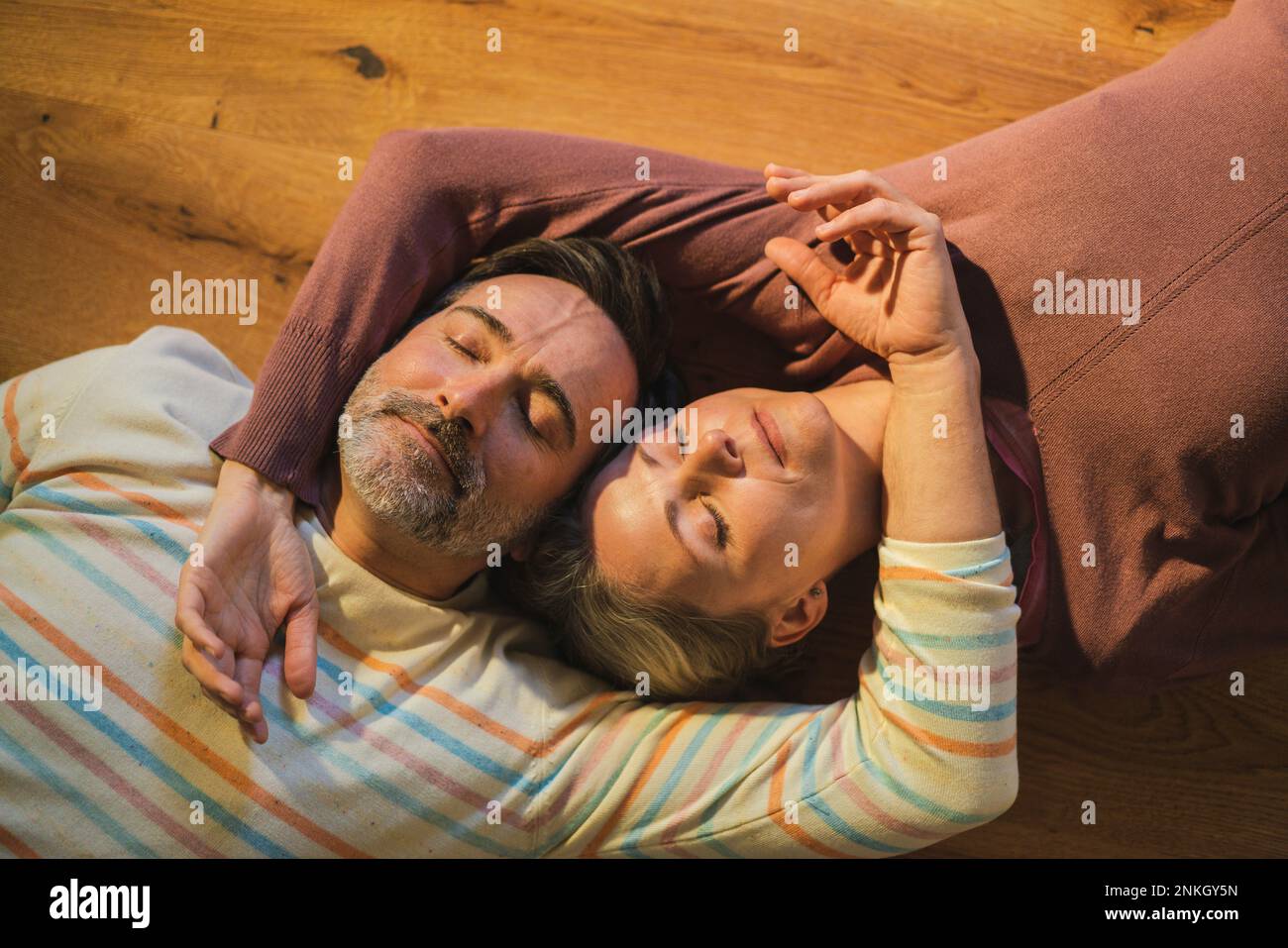 Man and woman lying down on floor at home Stock Photo - Alamy