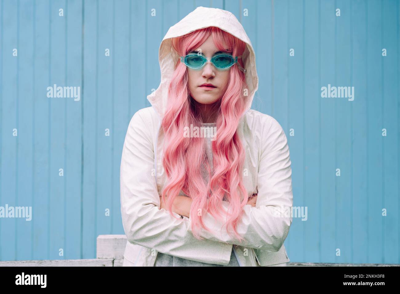 Woman with pink hair standing in front of wall Stock Photo