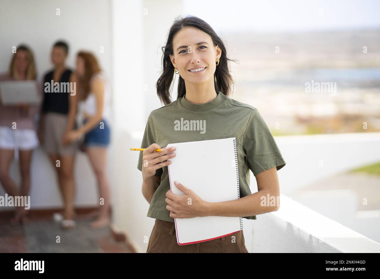 Smiling businesswoman holding spiral notebook Stock Photo