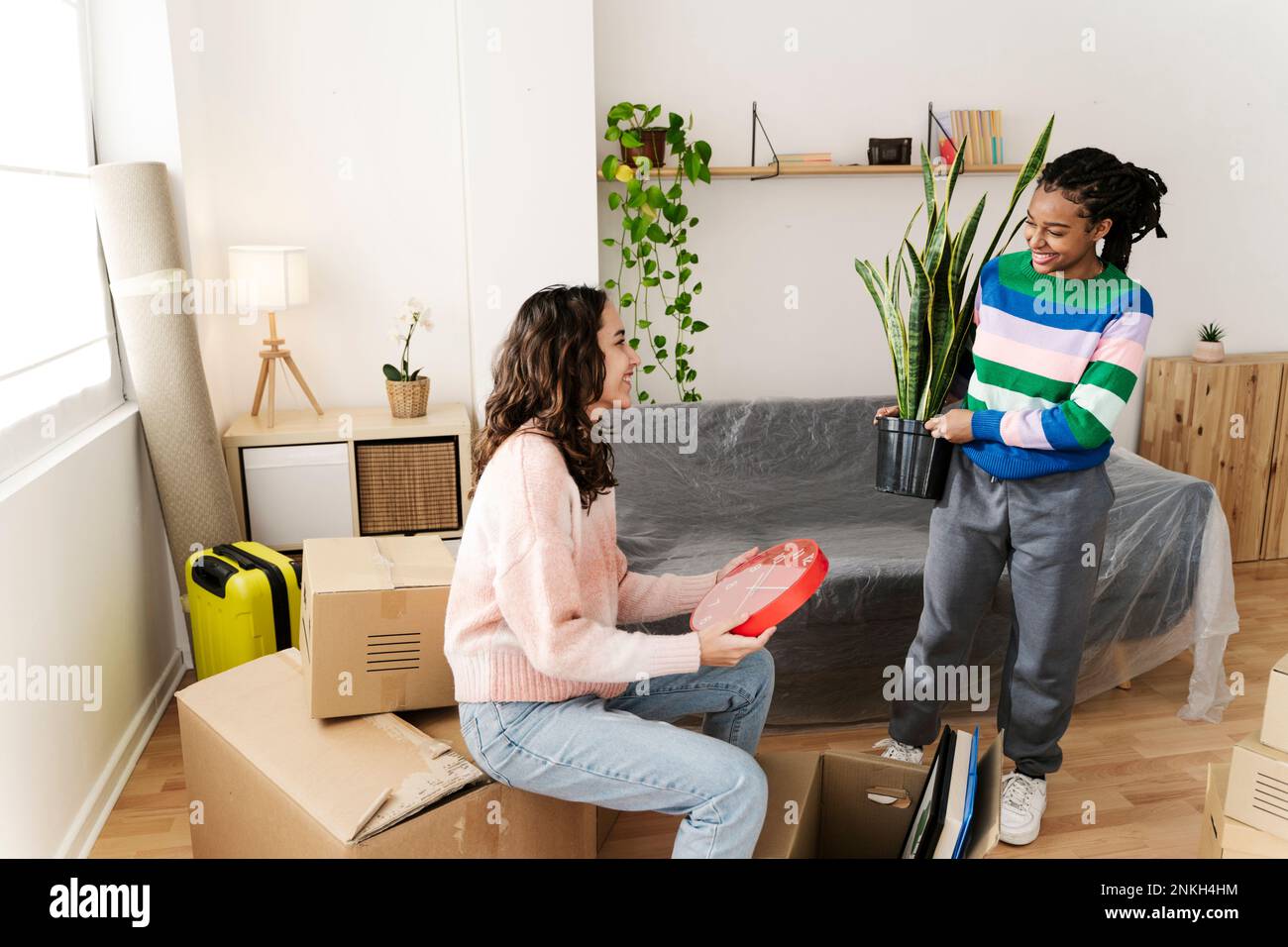 Excited friends unpacking box at home Stock Photo - Alamy