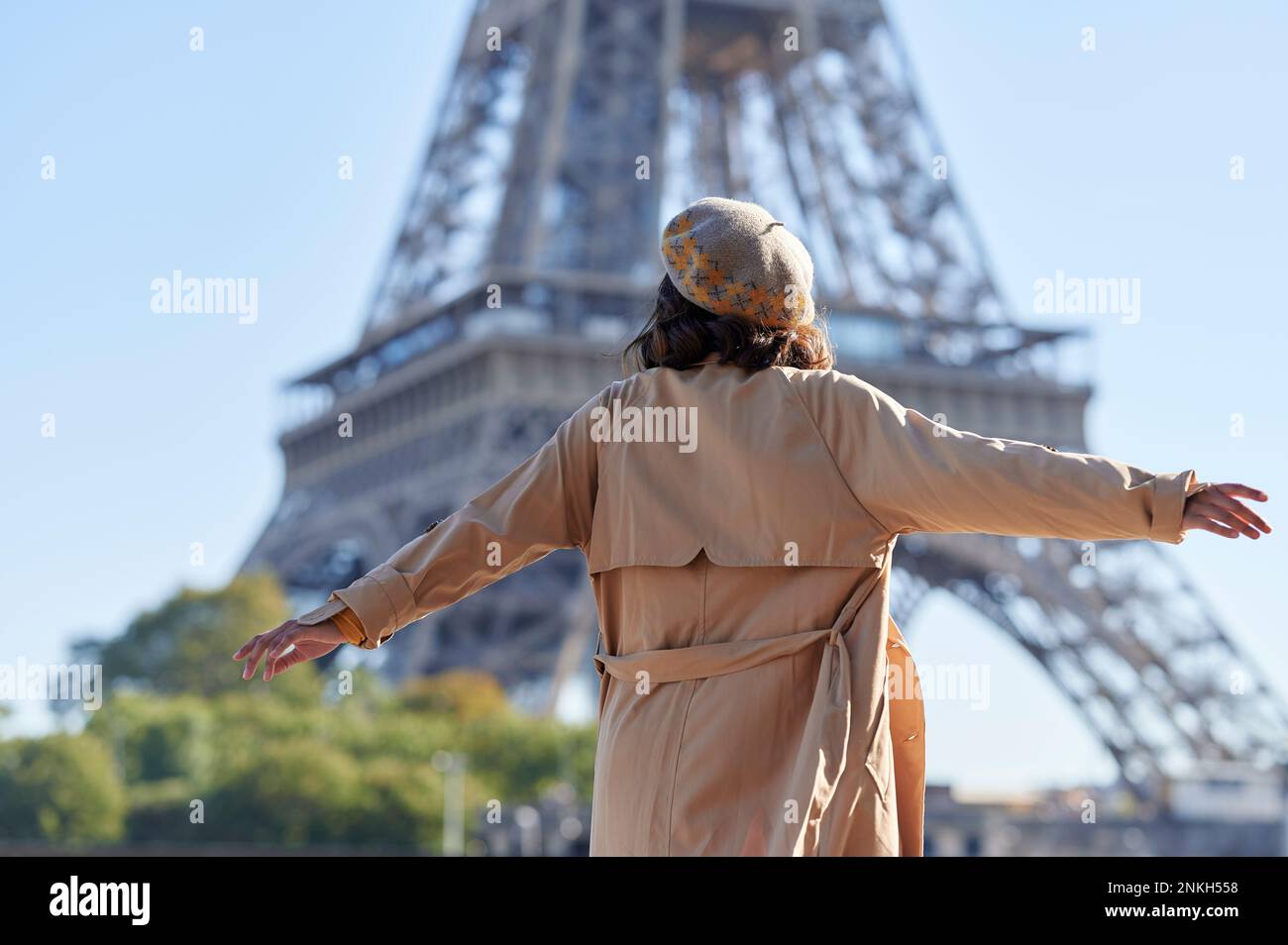 Woman with arms outstretched in front of Eiffel tower, Paris, France Stock Photo