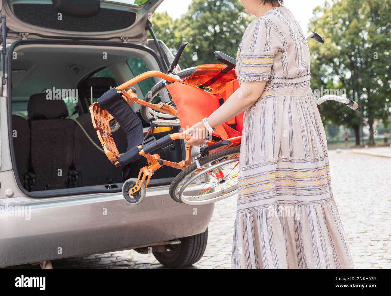 Mother loading wheelchair in car trunk Stock Photo Alamy