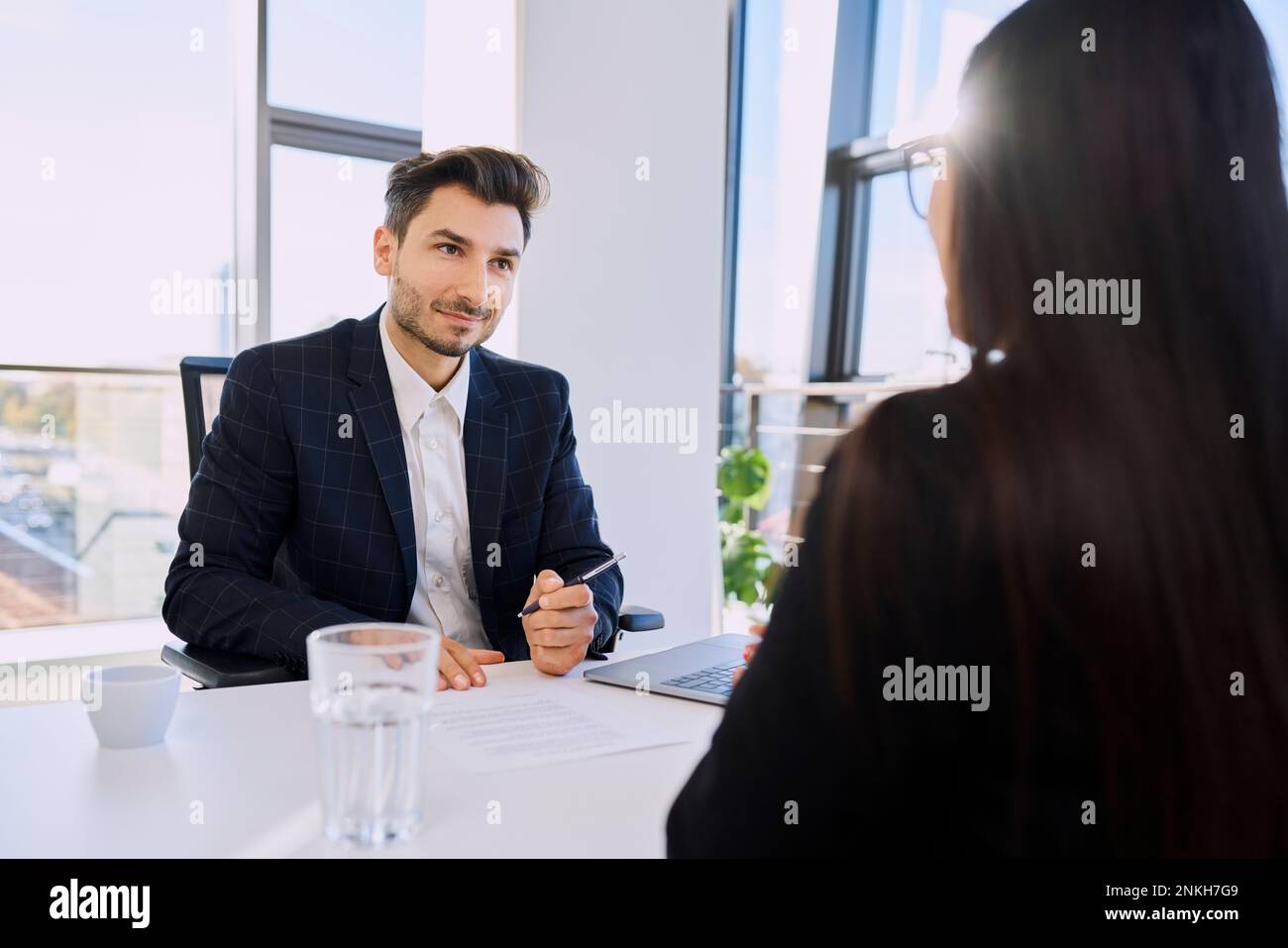 Recruiter with document talking to candidate in interview at office Stock Photo