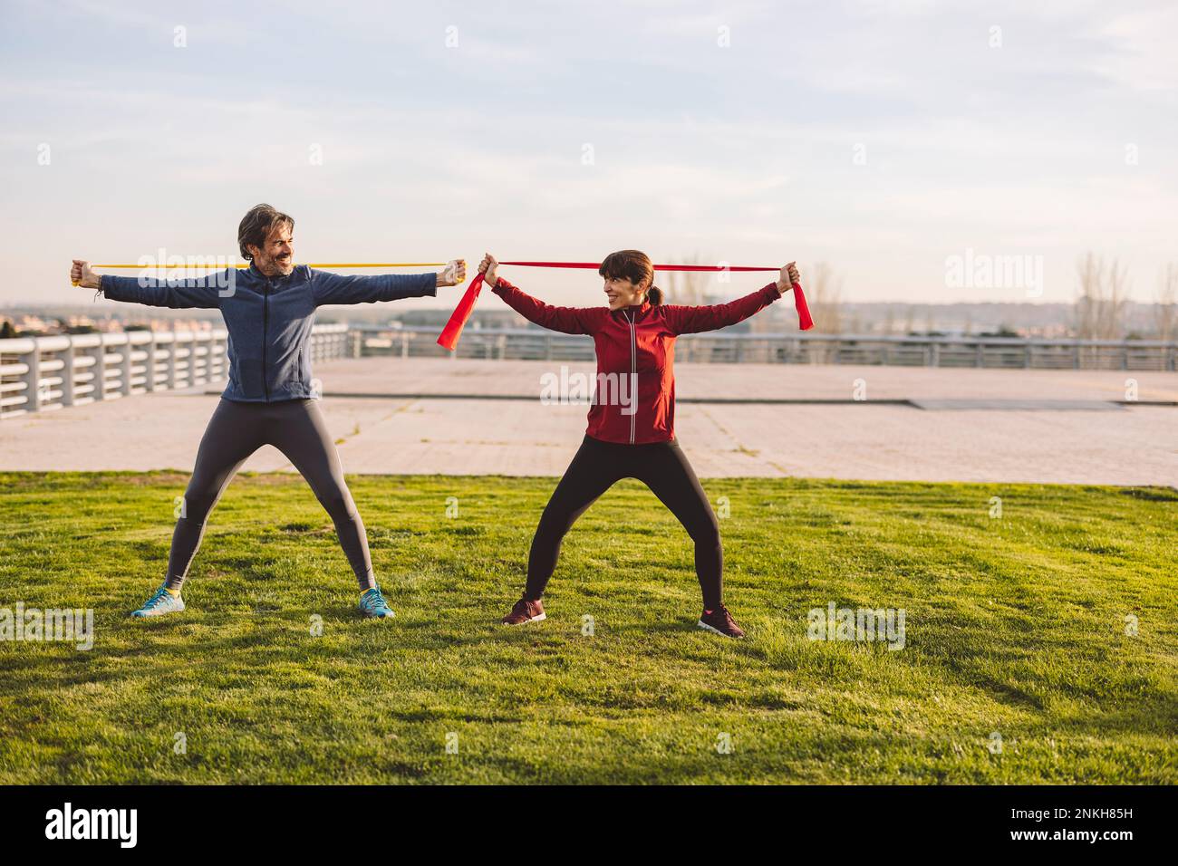 Happy mature couple exercising with resistance bands in park Stock Photo