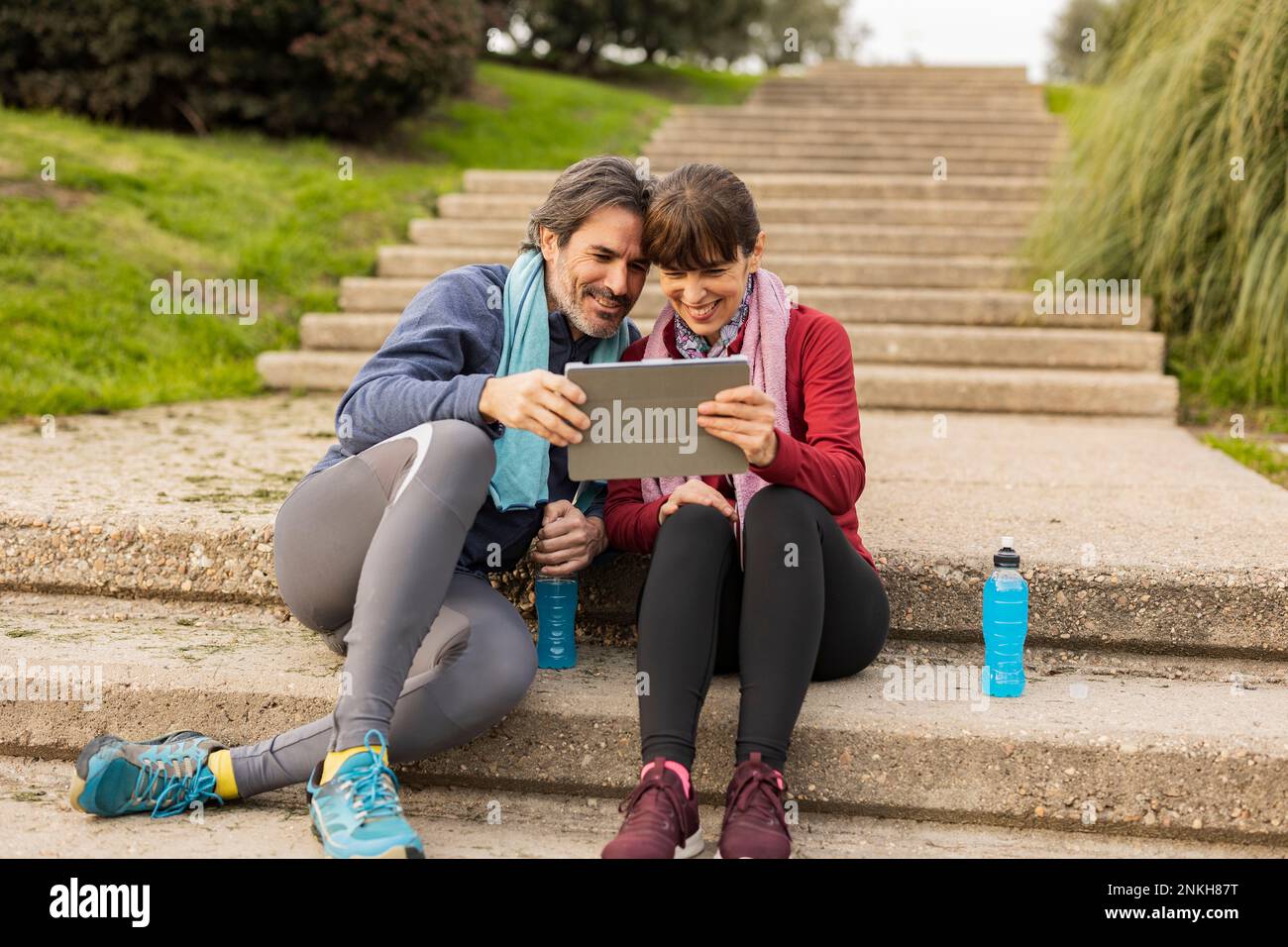 Happy mature couple using tablet PC on steps Stock Photo