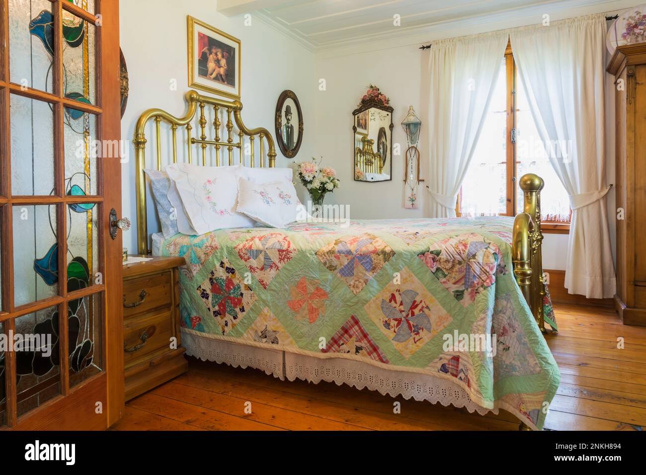 Double bed with antique brass headboard and footboard plus French door with stainedglass motifs