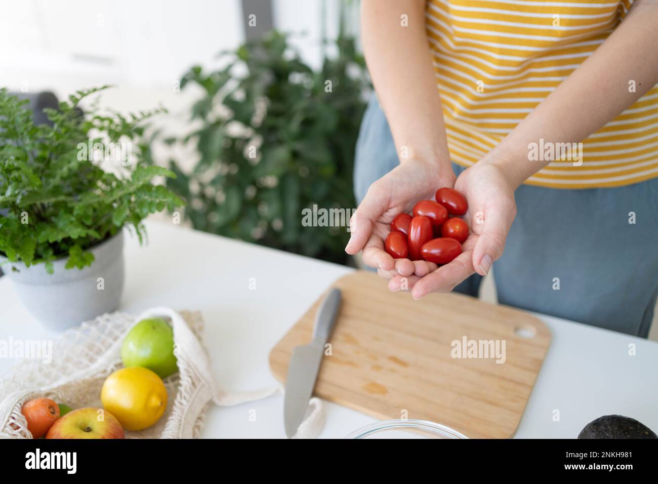 Woman holding cherry tomatoes in cupped hands at home Stock Photo - Alamy