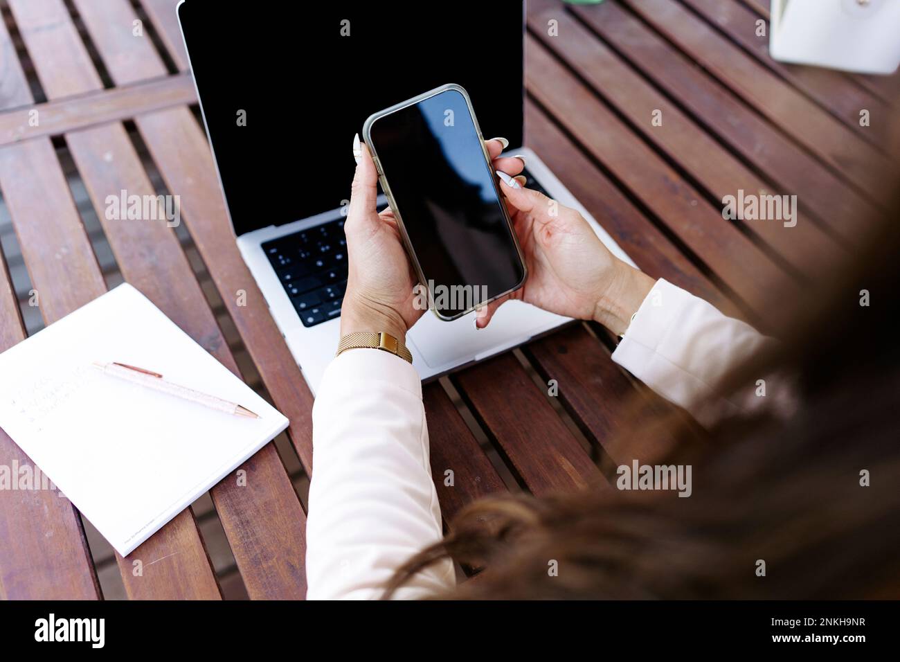 Freelancer using smart phone at table Stock Photo