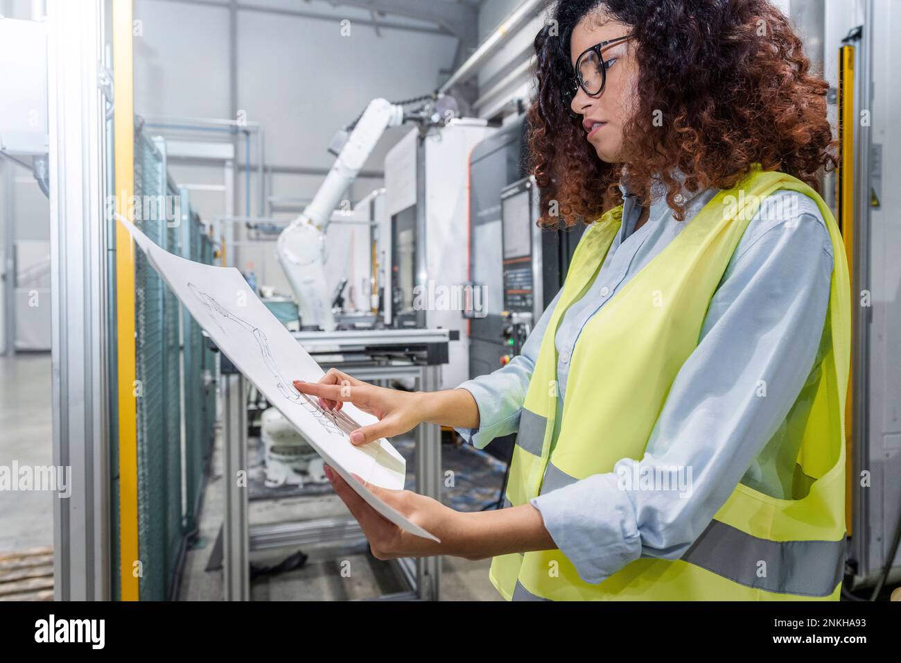 Young engineer examining blueprints in industry Stock Photo