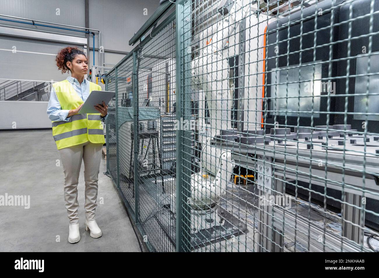 Young engineer using tablet PC by machine in industry Stock Photo