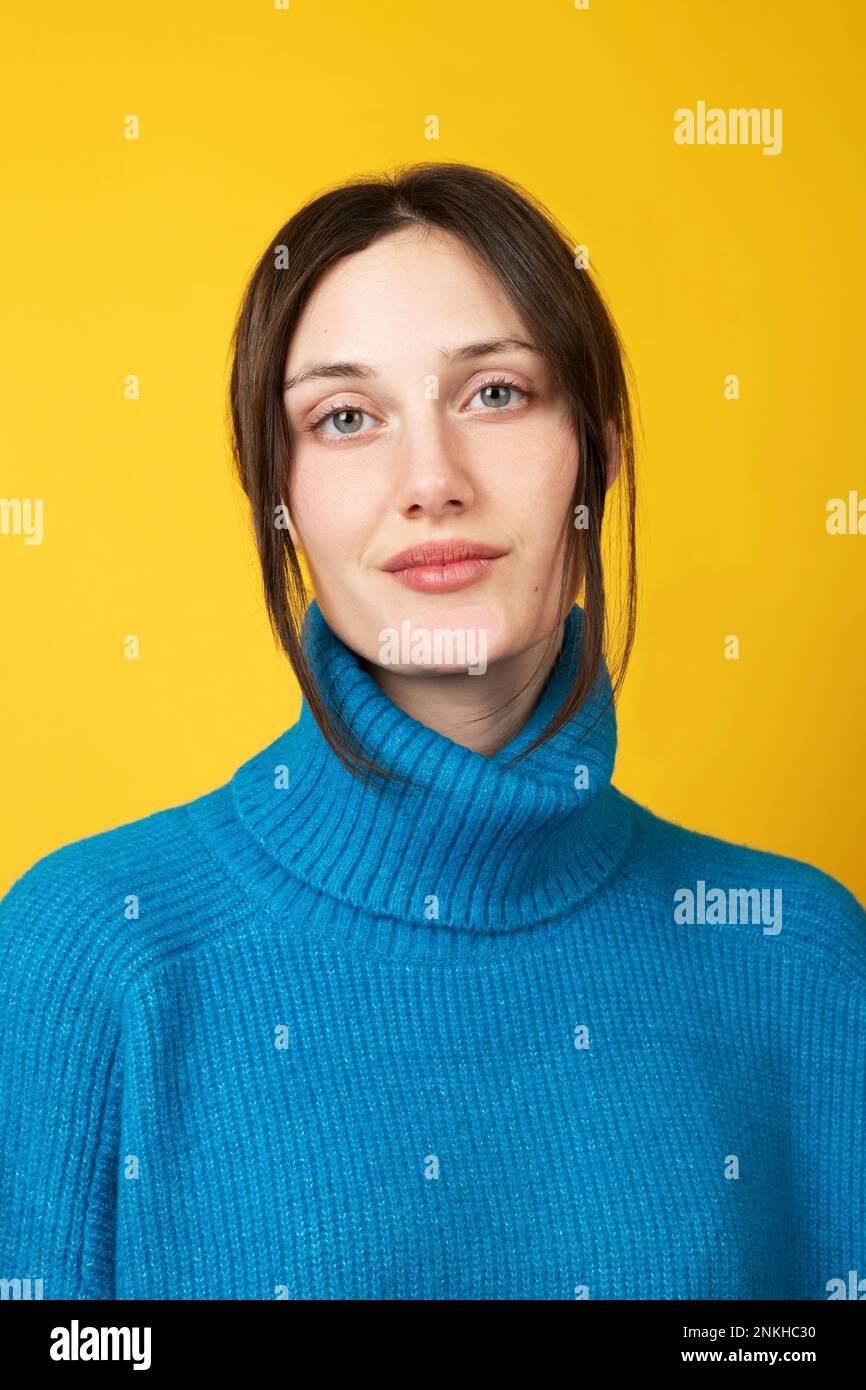 Young beautiful woman wearing blue turtleneck over yellow background Stock Photo