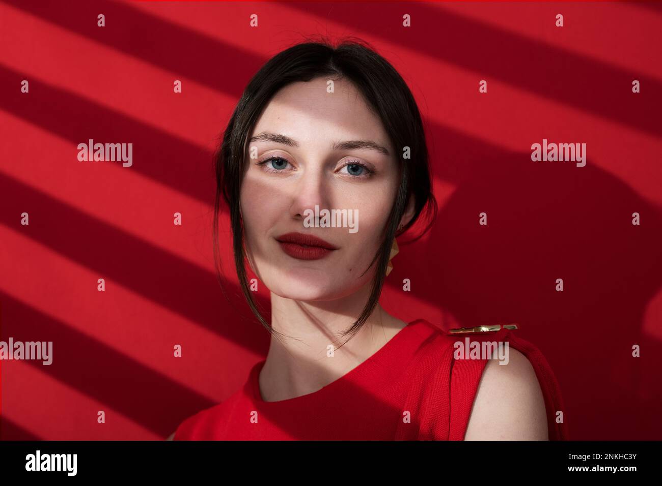 Beautiful young woman wearing red lipstick over colored background Stock Photo