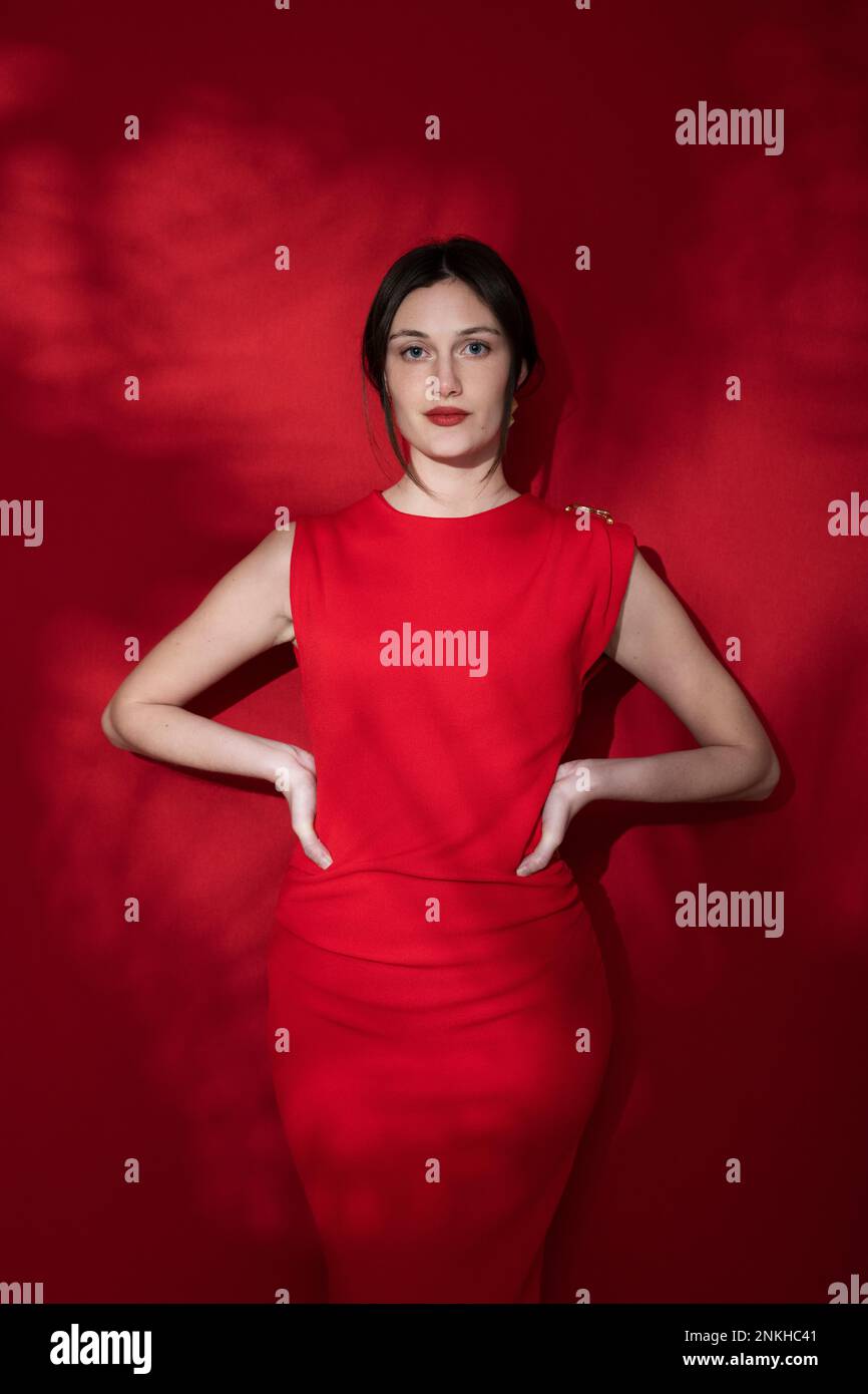 Confident woman with hands on hips against red background Stock Photo ...
