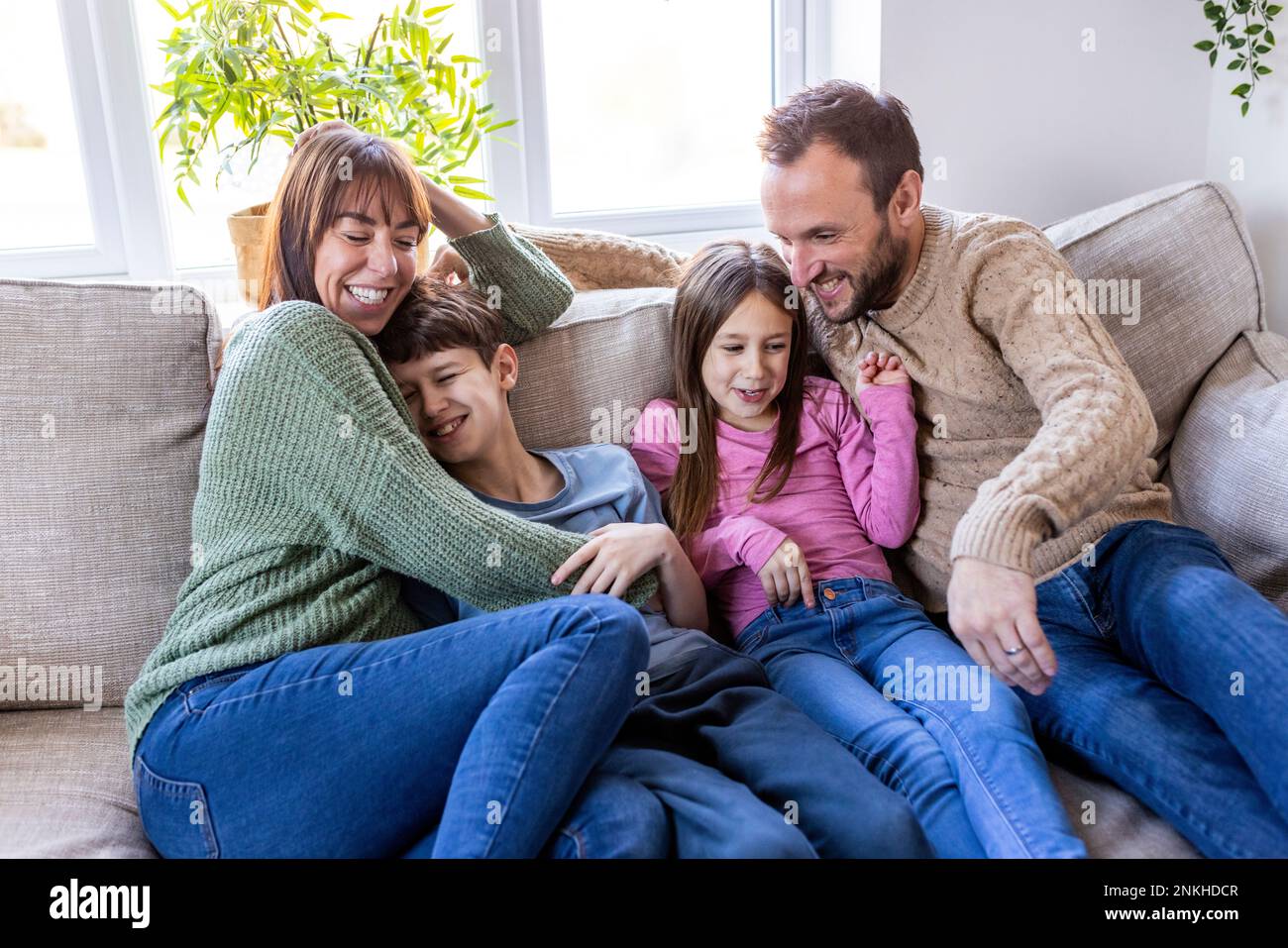 Happy man and woman spending time with children at home Stock Photo