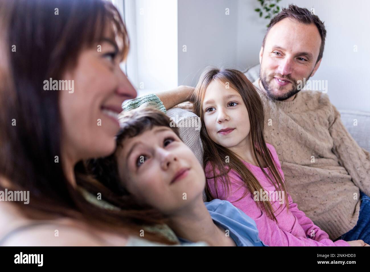 Smiling woman spending time with family at home Stock Photo
