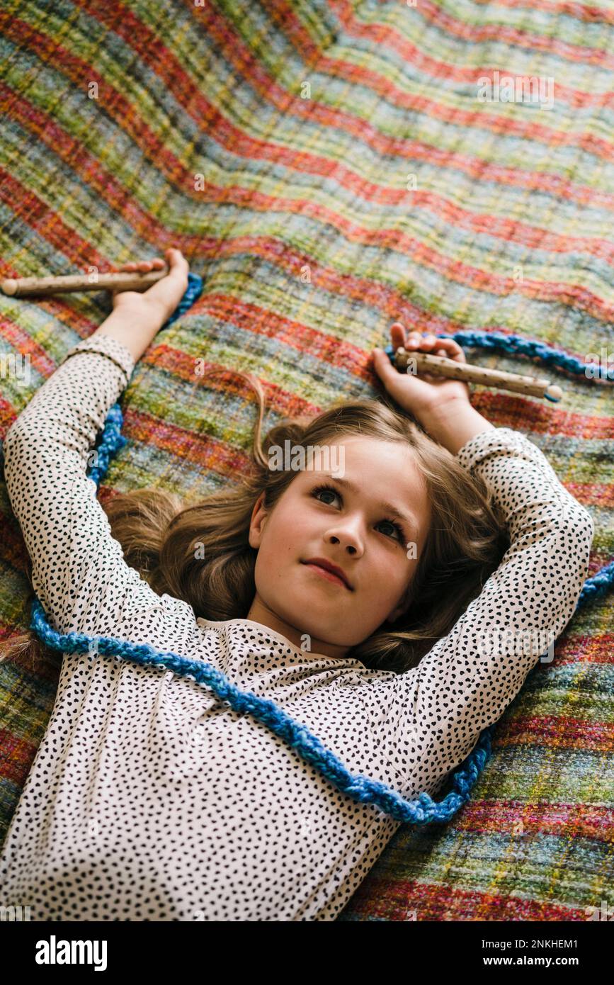 Thoughtful girl with jump rope lying on bed at home Stock Photo