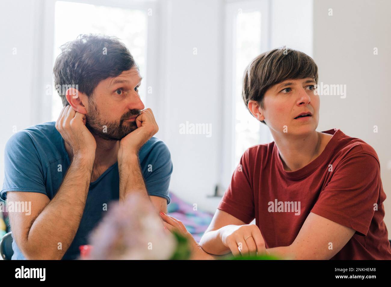Worried mature couple sitting together at home Stock Photo