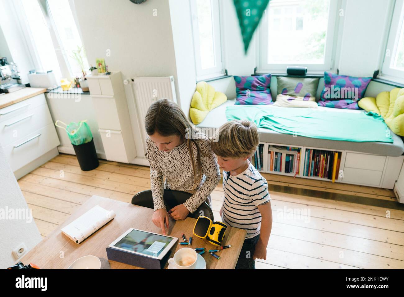 Girl using tablet PC by brother at home Stock Photo