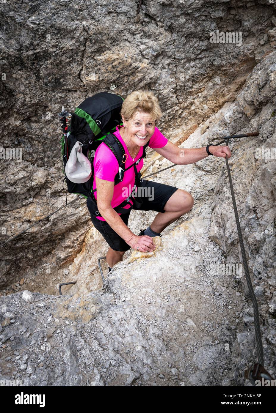 Active senior woman climbing rock Stock Photo