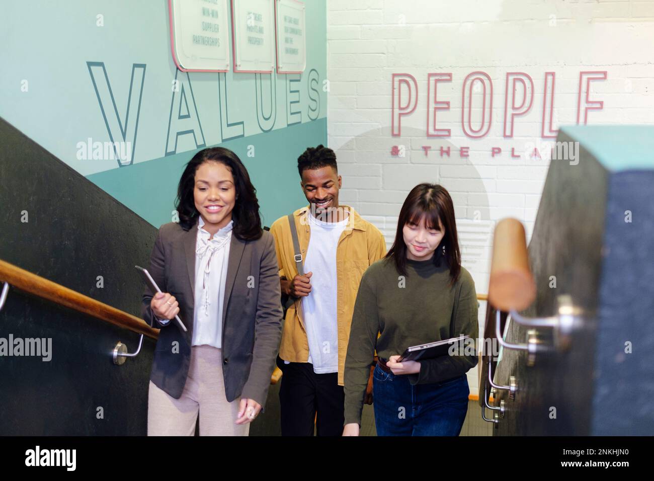 Multiracial business colleagues moving up on steps at office Stock Photo