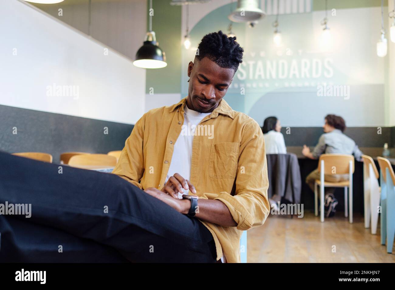 Businessman using smart watch sitting at office Stock Photo