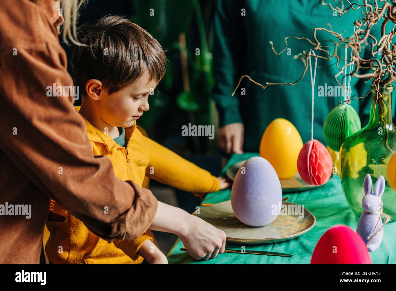 Mother and son decorating Easter dinner table at home Stock Photo