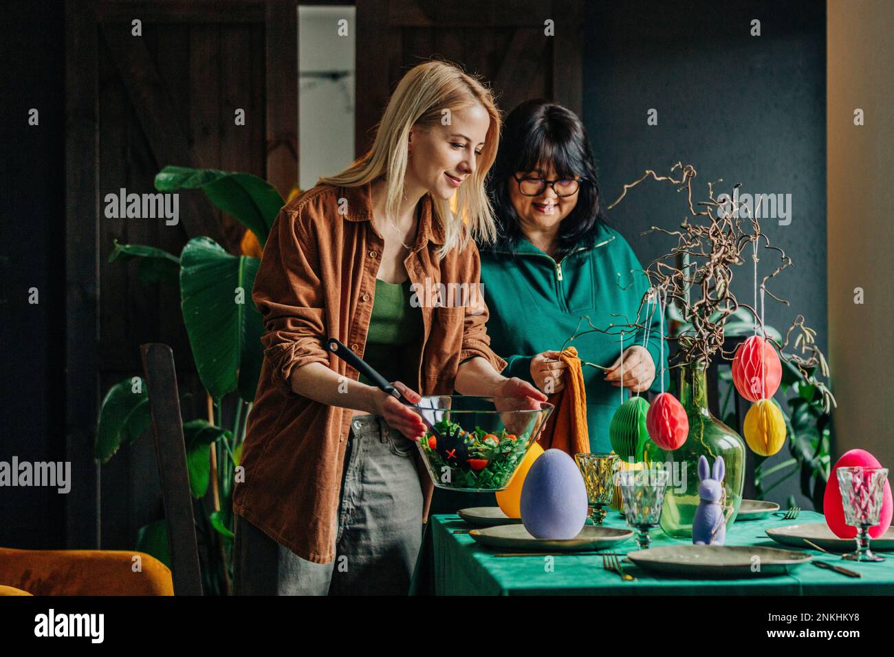 Happy woman with mother setting table for Easter dinner at home Stock ...