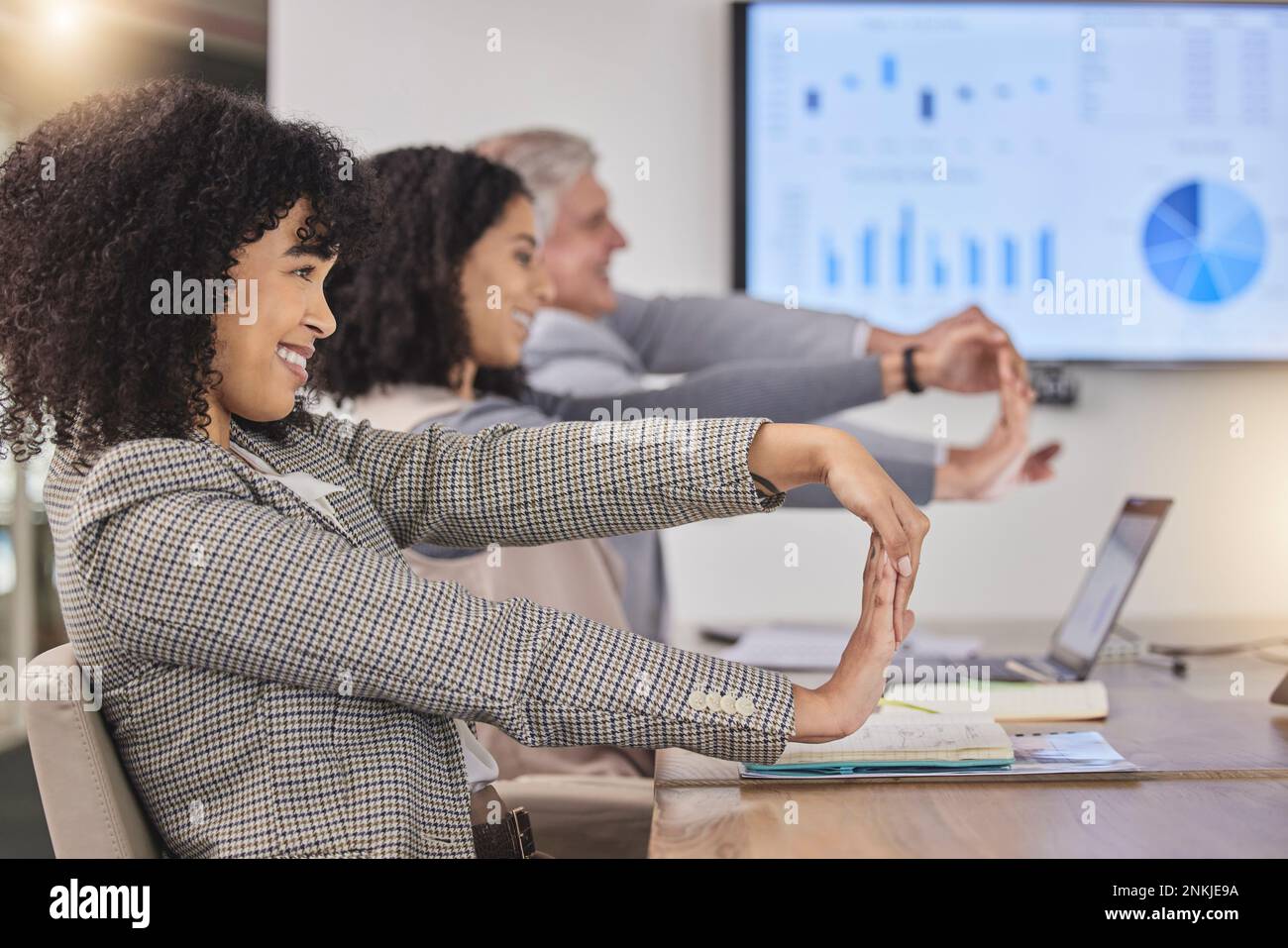 Business people, desk and stretching arms at meeting for finance, budget and accounting presentation. Group, corporate team building and diversity Stock Photo