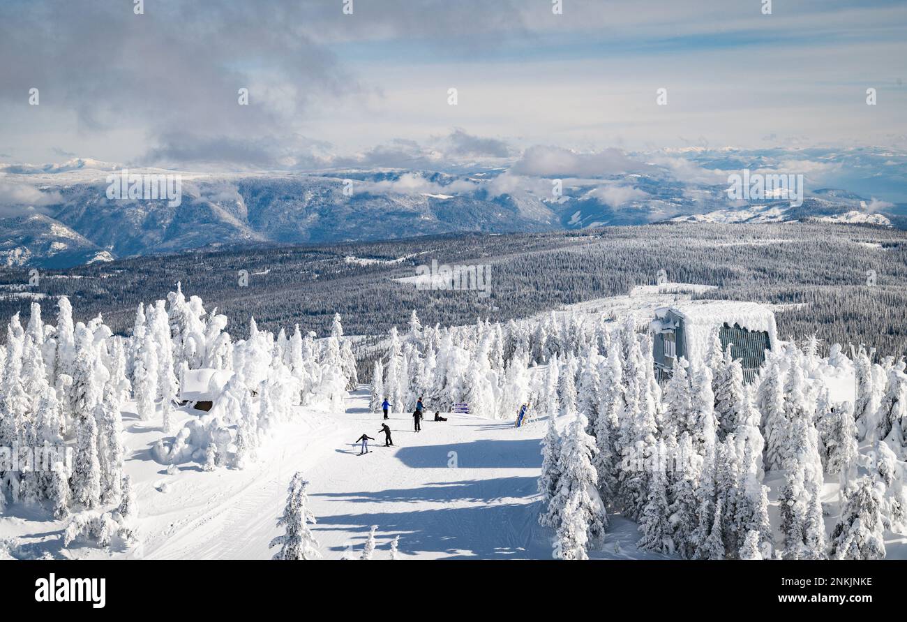 Photo of skiers and snowboarders heading down the mountain from the Crystal lift at the 'Top of the World' peak at Sun Peaks ski resort. Stock Photo