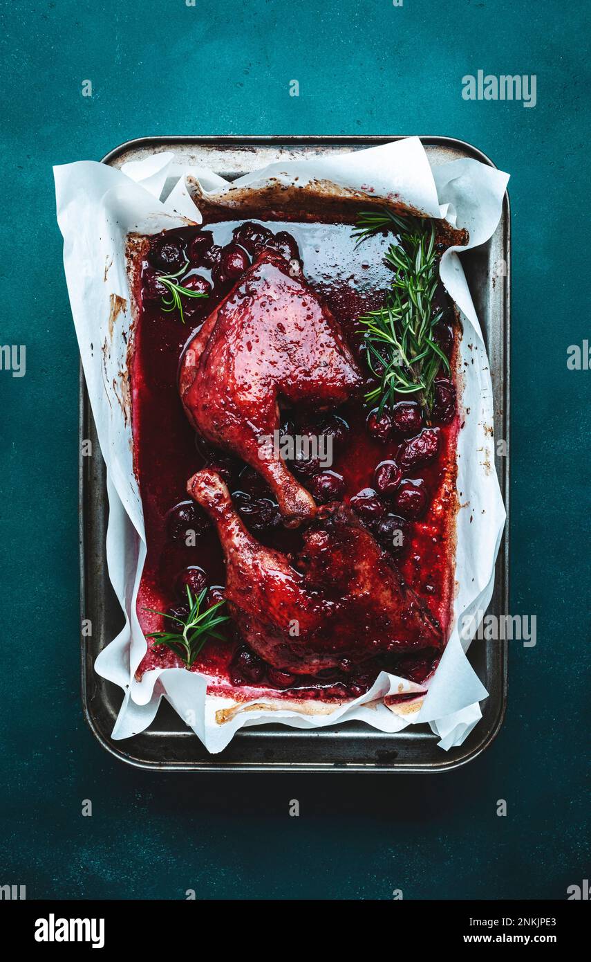 Baked duck legs with cherry red wine sauce with fresh rosemary in old