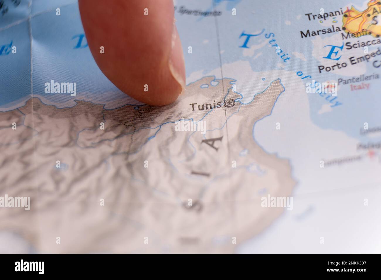 Finger pointing to Tunis, Tunisia on detailed map with selective focus, shallow depth of field, background blur Stock Photo